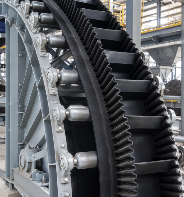 Sidewall conveyor belt with corrugated sidewalls and cleats for steep-angle material conveying